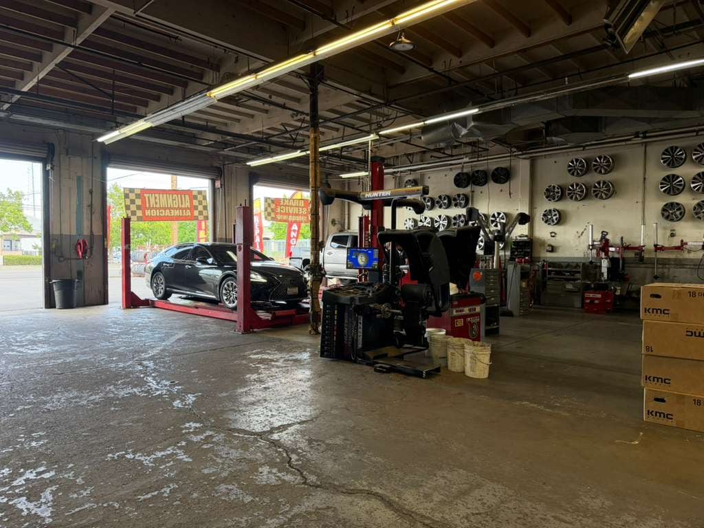 Lexus on a 2-post lift inside the shop